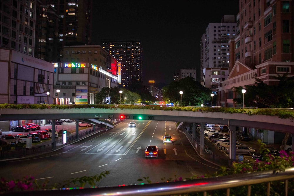 a city street at night with cars driving on it