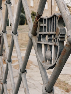 Close-up of a sturdy metal fence with personalized design elements in an outdoor setting.