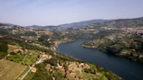 A stunning aerial shot of the Douro River winding through lush vineyards at sunset.