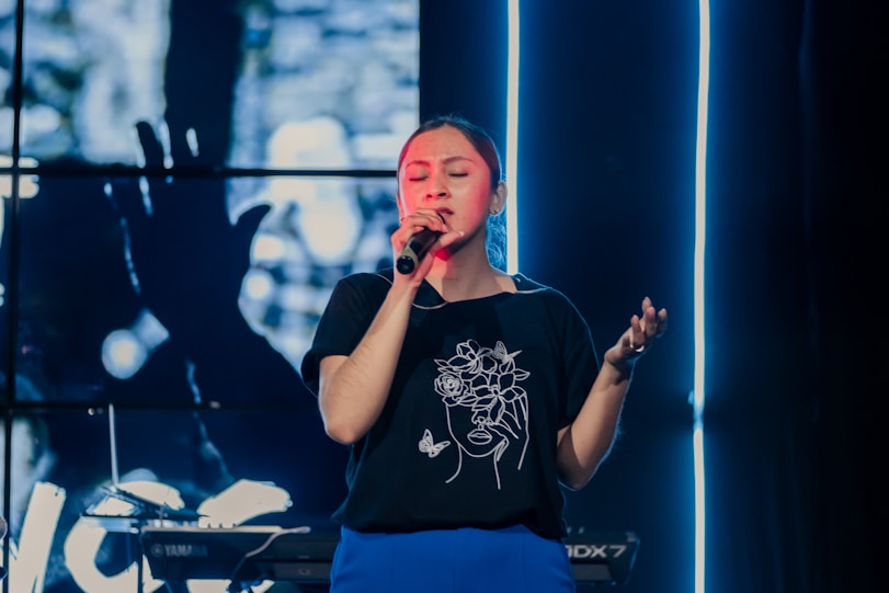 a woman singing into a microphone on stage