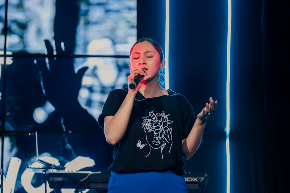 a woman singing into a microphone on stage