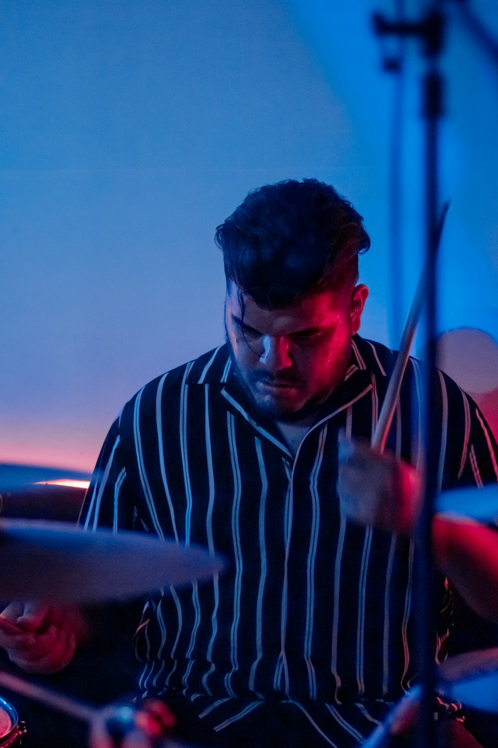 a man playing drums in a dark room