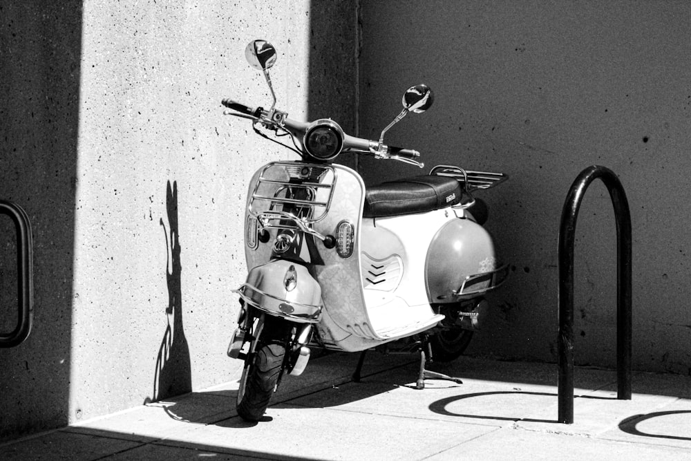 a motor scooter parked next to a wall