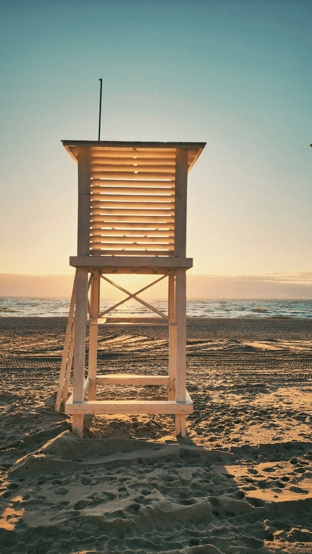 a lifeguard tower sitting on top of a sandy beach