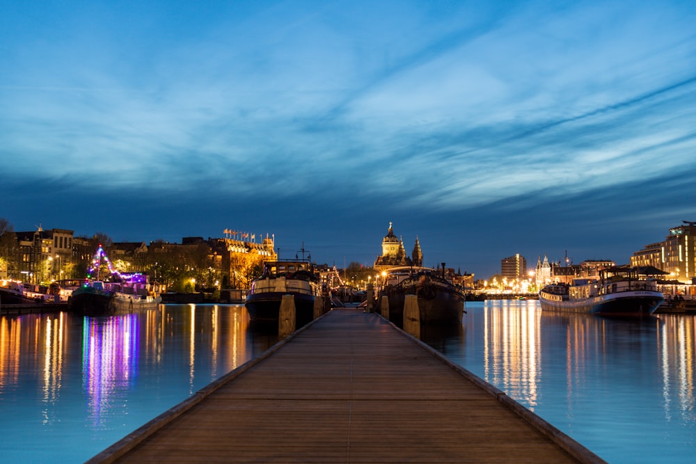 a long dock in front of a city at night