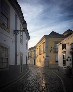 A charming cobblestone street in Florence with historic buildings bathed in warm sunlight.