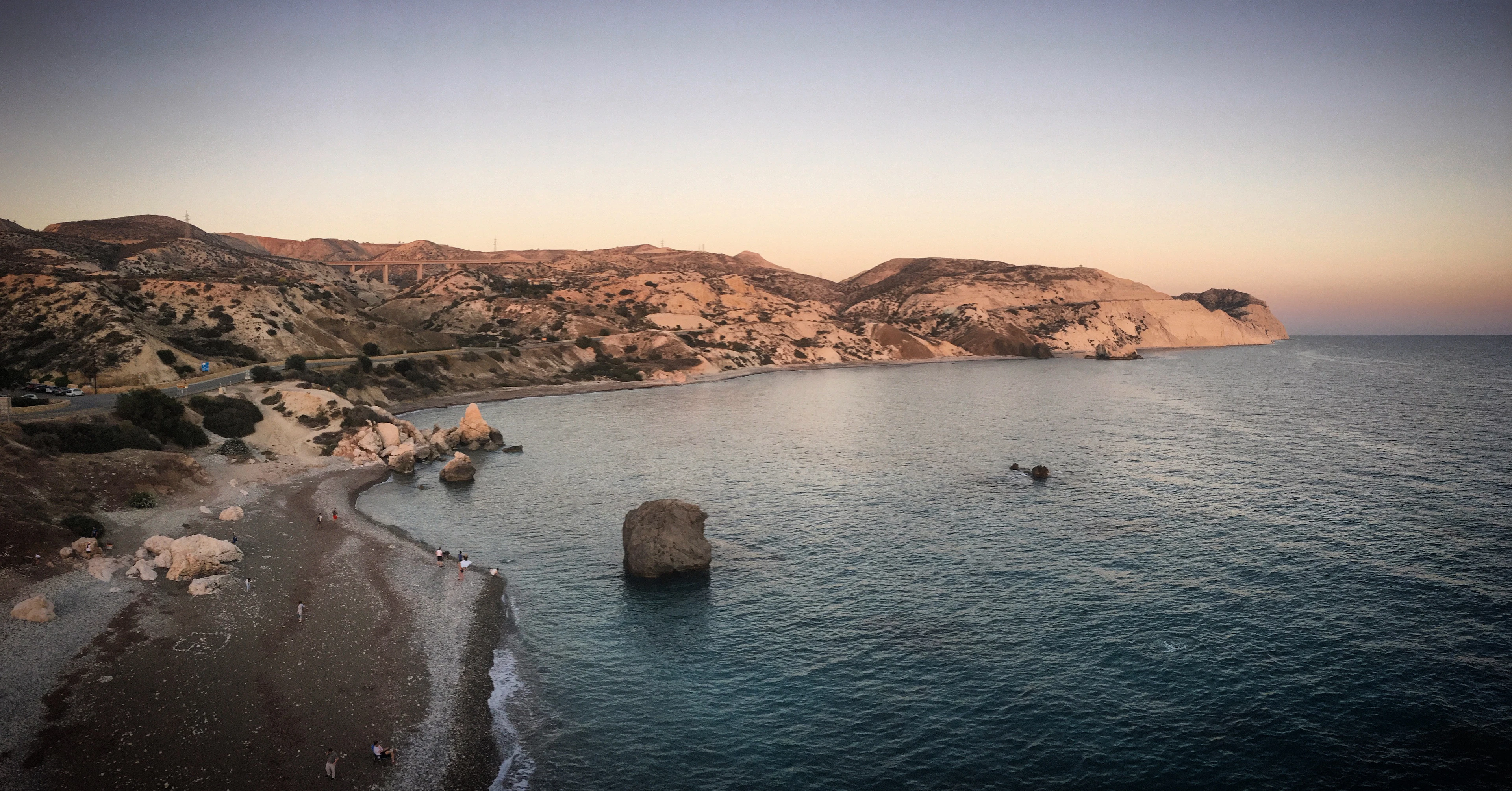 Dusk on the rocky coast near Paphos, the sea flat and pale between low headlands
