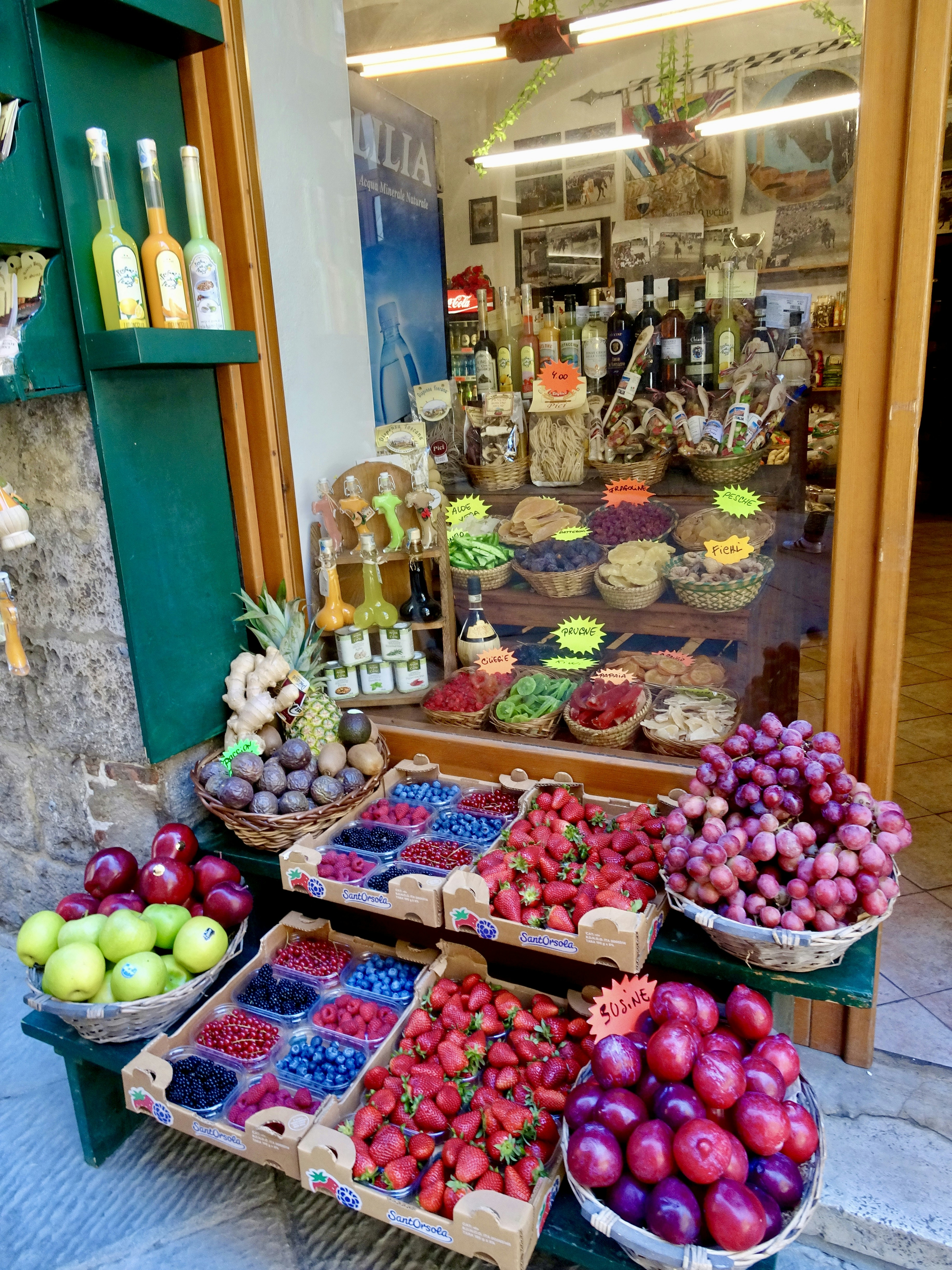 A display of fruits and vegetables in front of a store photo Free