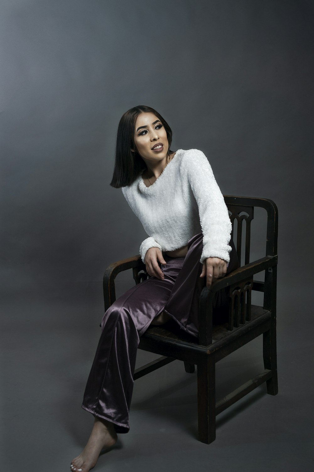 a woman is sitting on a chair posing for a picture
