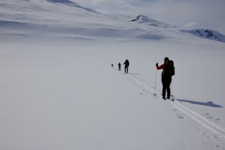 a group of people walking across a snow covered field