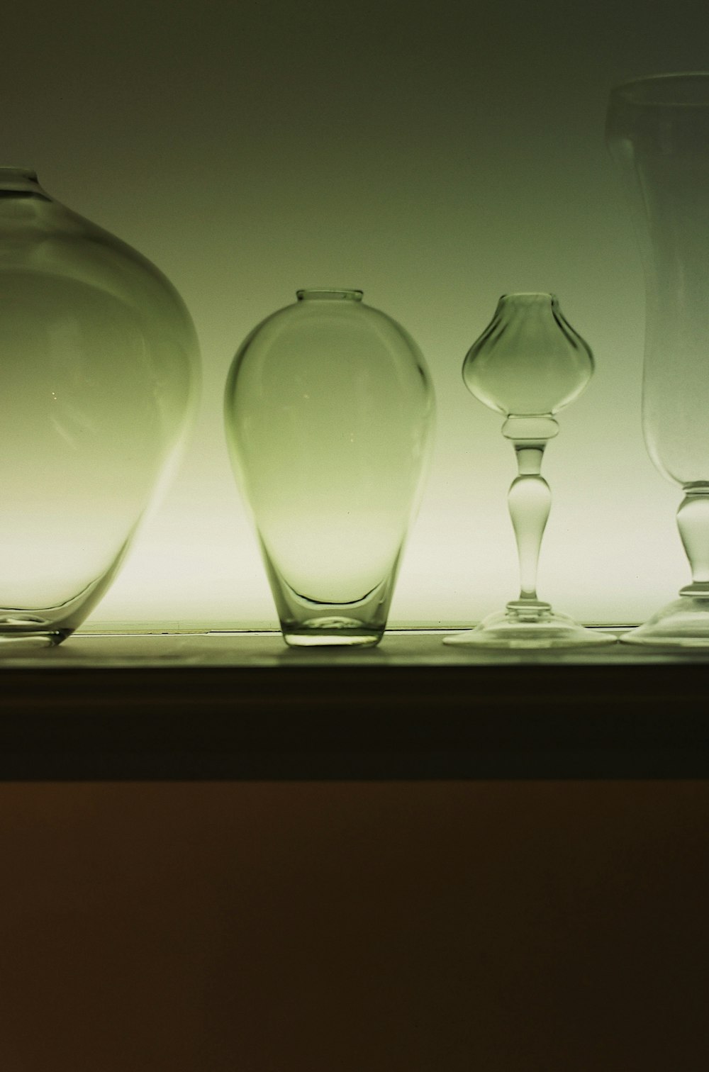 a row of glass vases sitting on a shelf