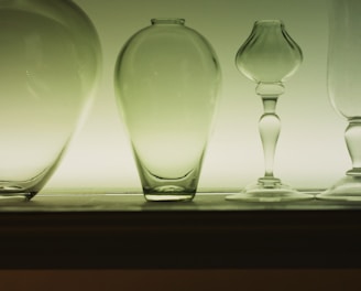 a row of glass vases sitting on a shelf