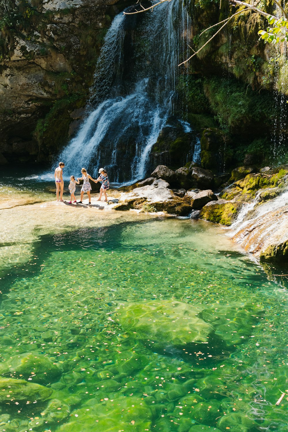 a group of people standing in front of a waterfall