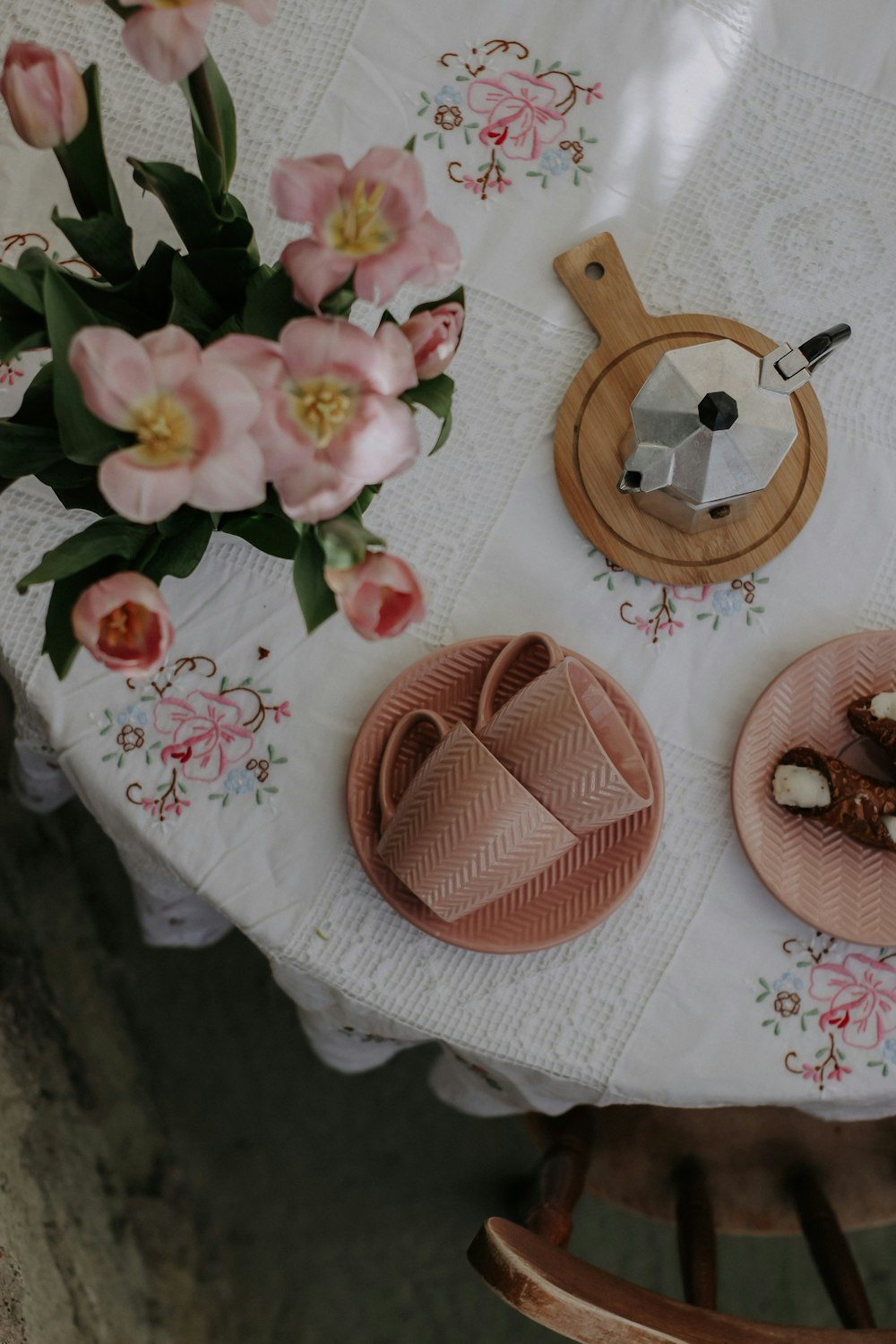 a white table topped with plates of food and flowers