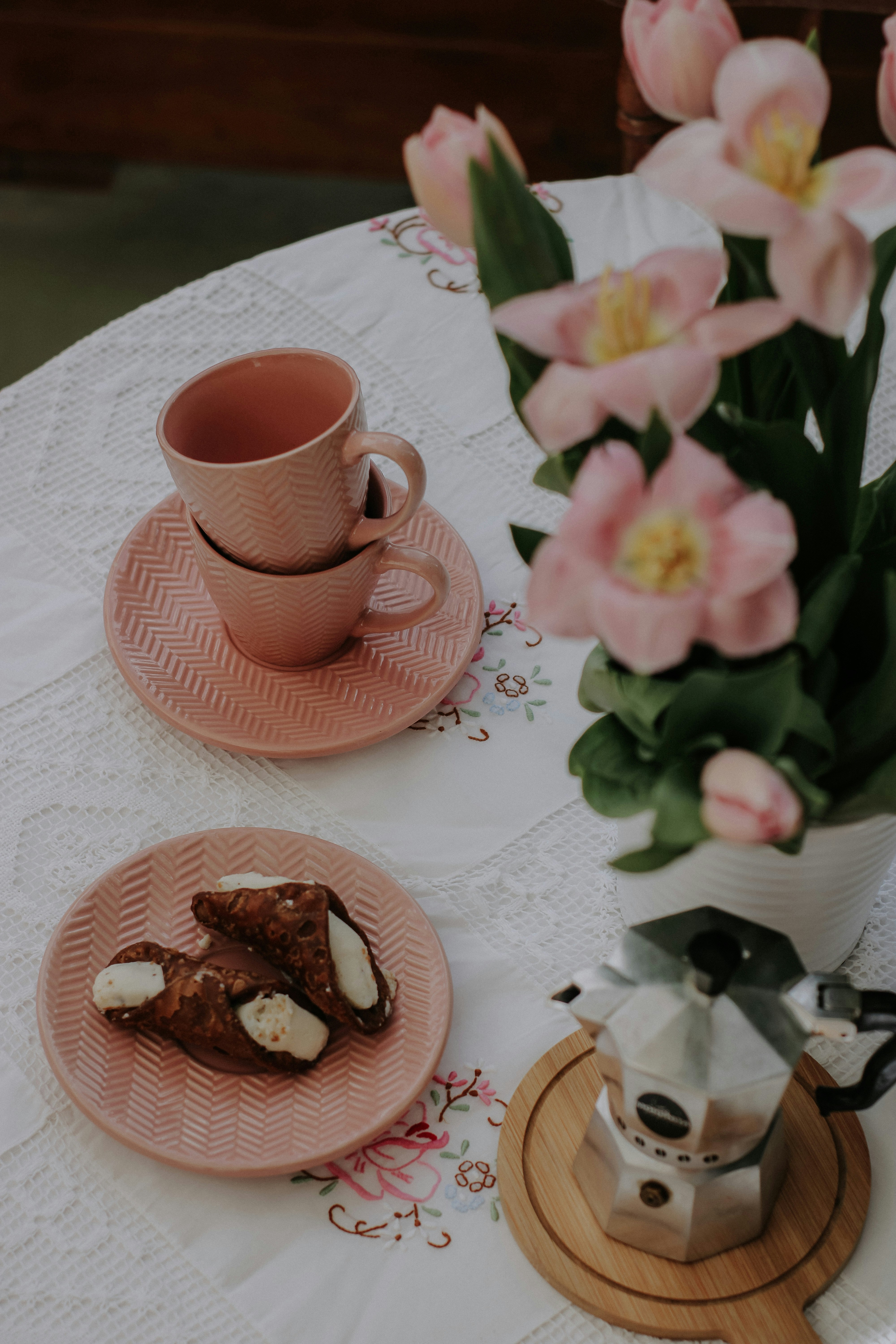 a table topped with plates of food and a vase of flowers