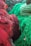 Vibrant coils of colorful fishing nets, predominantly in shades of red and green, are piled together. The texture of the nets is intricate, showcasing loops and knots, creating a rich visual tapestry.