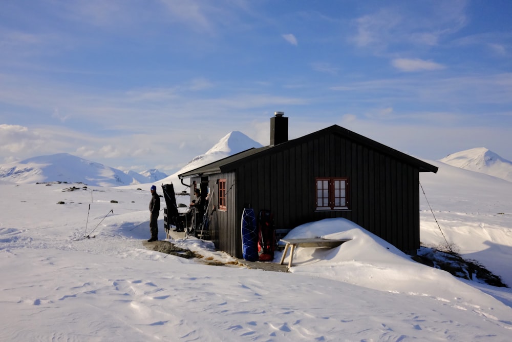 a small cabin in the middle of a snowy field