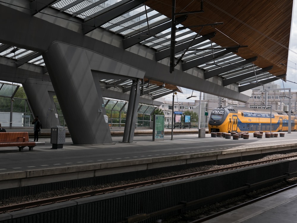 um trem amarelo e azul em uma estação de trem