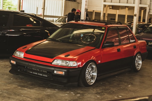 Side view of a lowered Gol with neon red accents under dark garage lighting.