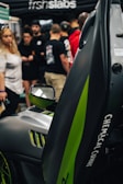 Close-up of a green-themed car branding event with influencers engaging the crowd.