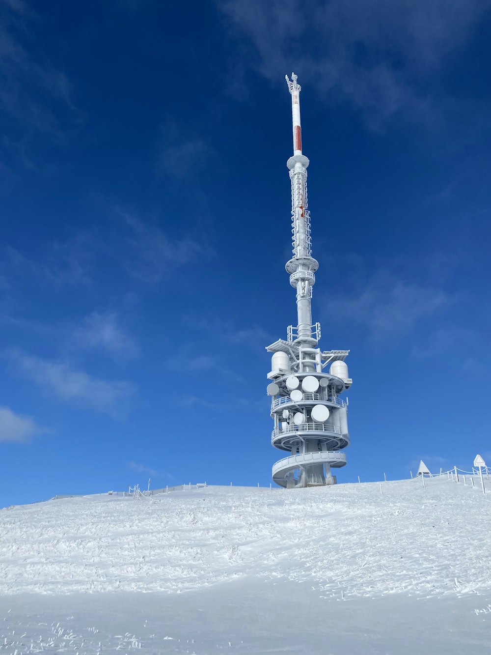 Ein Mobilfunkmast inmitten eines verschneiten Feldes