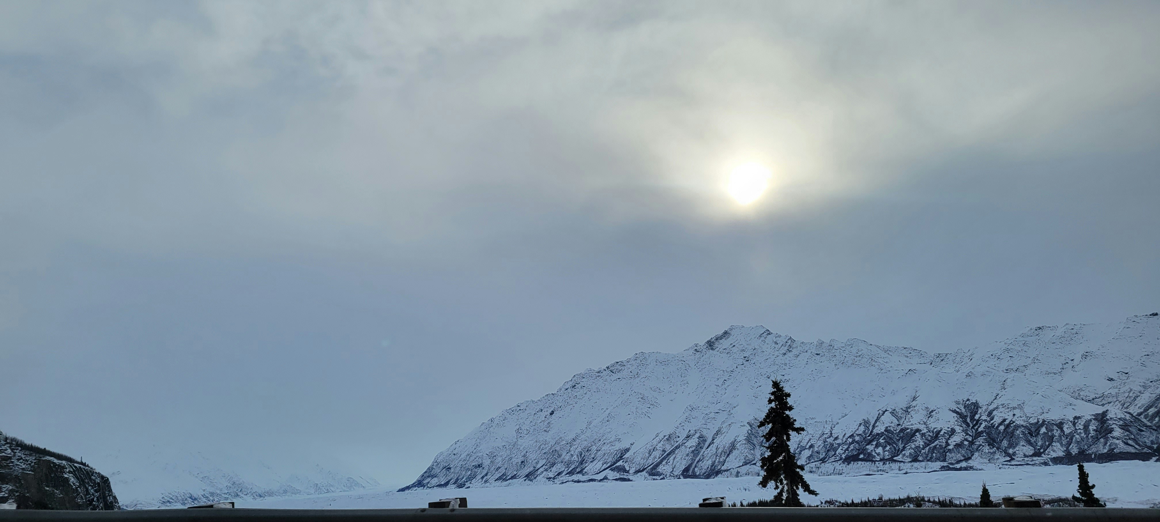 The sun is shining over a snowy mountain range photo – Free Fir Image ...