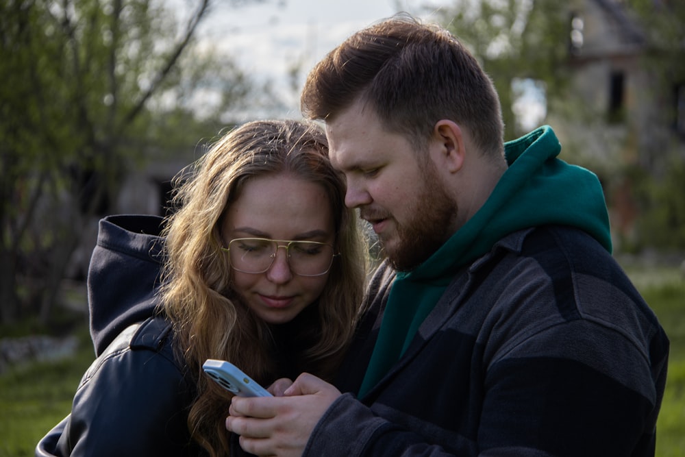 a man and a woman looking at a cell phone