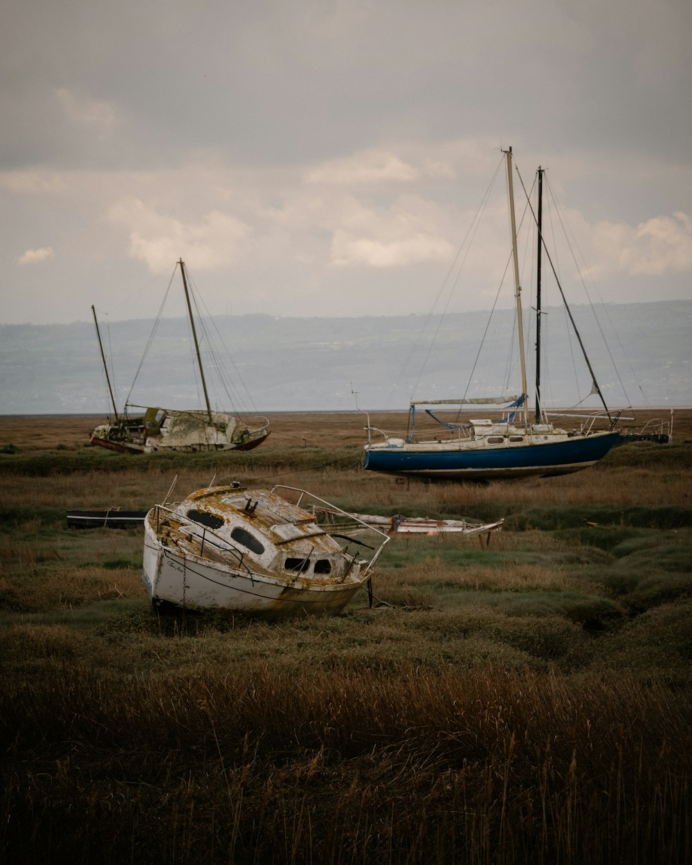 a couple of boats that are sitting in the grass