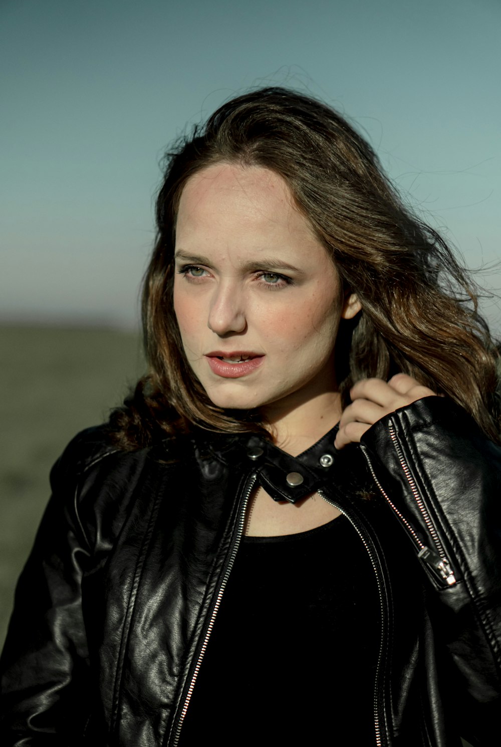a woman in a black shirt and a black leather jacket