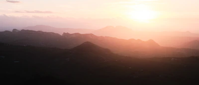 A serene landscape with mountains and a sunset.