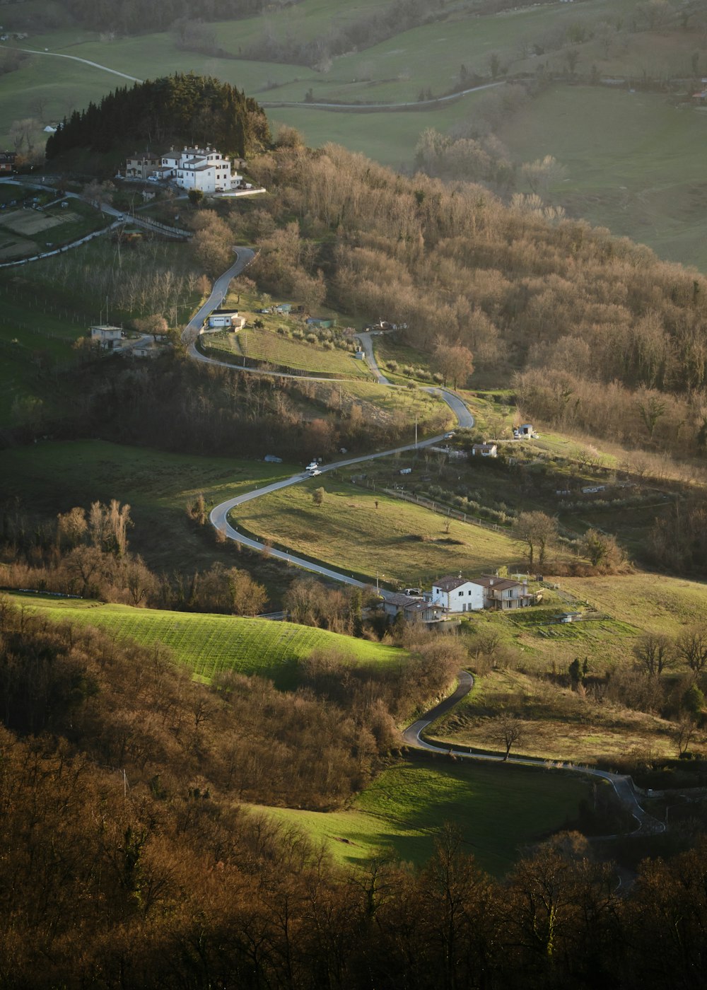 a winding road in the middle of a lush green hillside