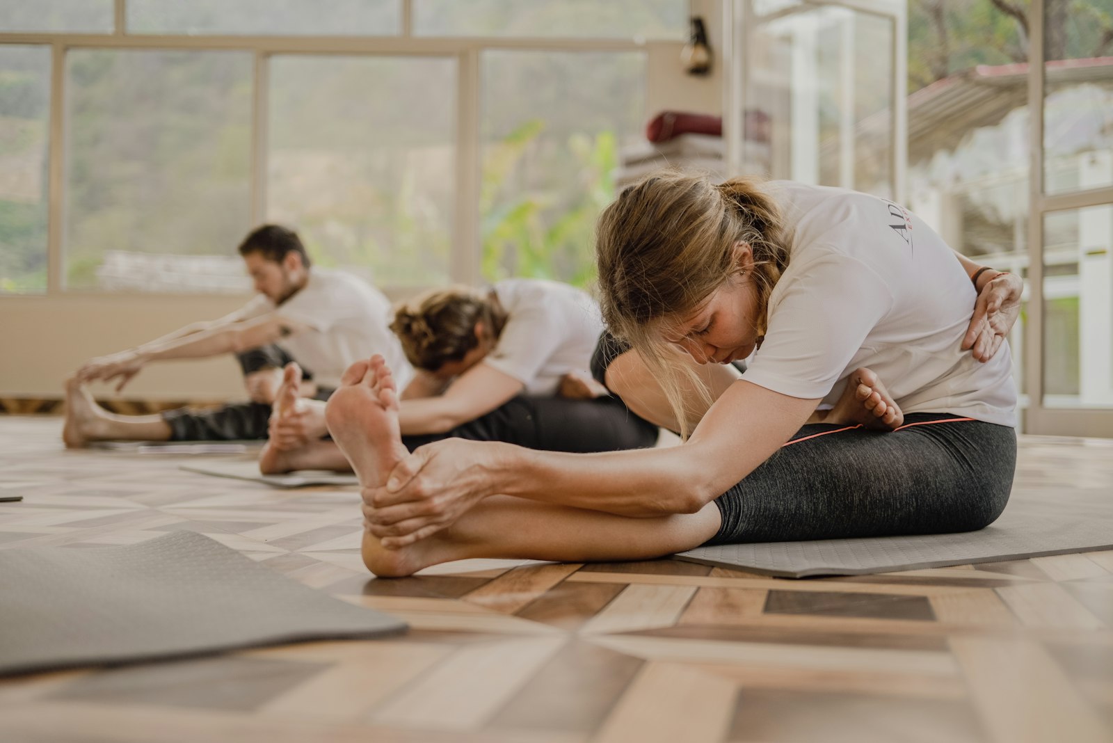 Yogastunde in hellem Studioraum — Gruppe übt gemeinsam auf Matten