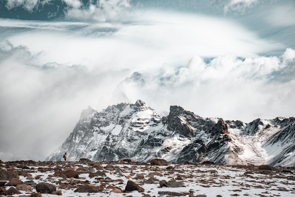 a mountain range covered in snow under a cloudy sky