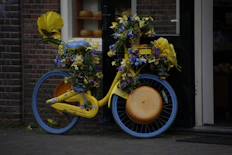 a yellow bicycle with flowers on the front wheel