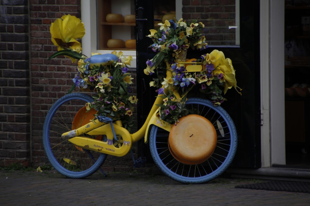 a yellow bicycle with flowers on the front wheel