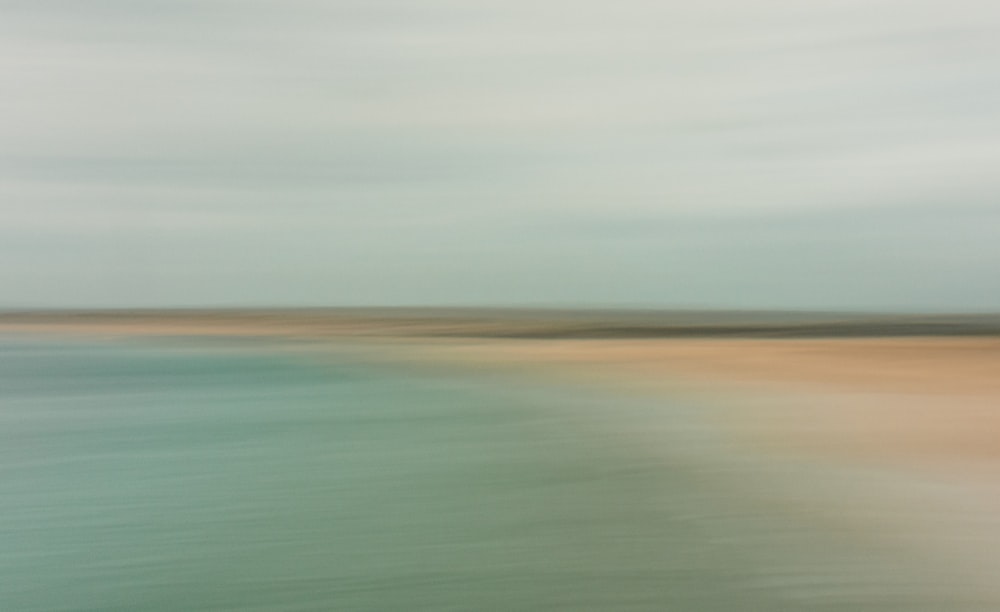 a blurry photo of a beach and water