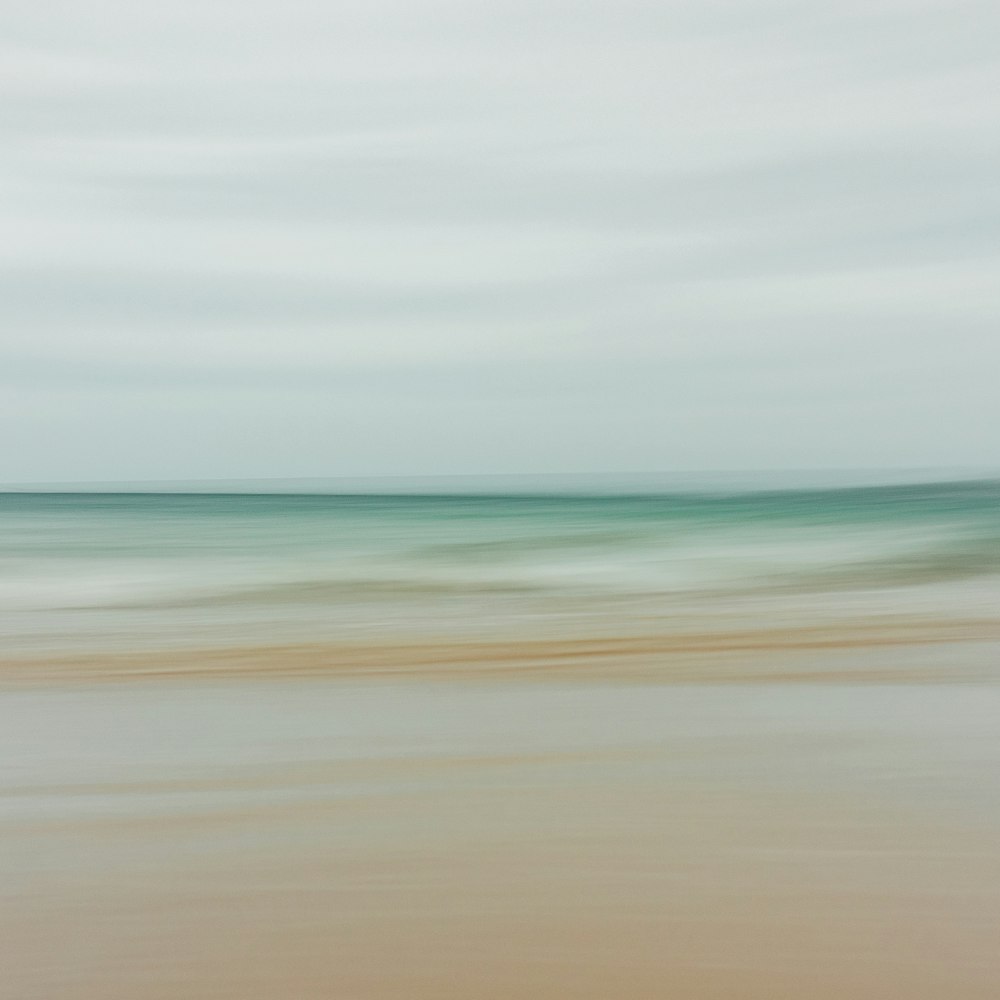 a blurry photo of a beach with waves