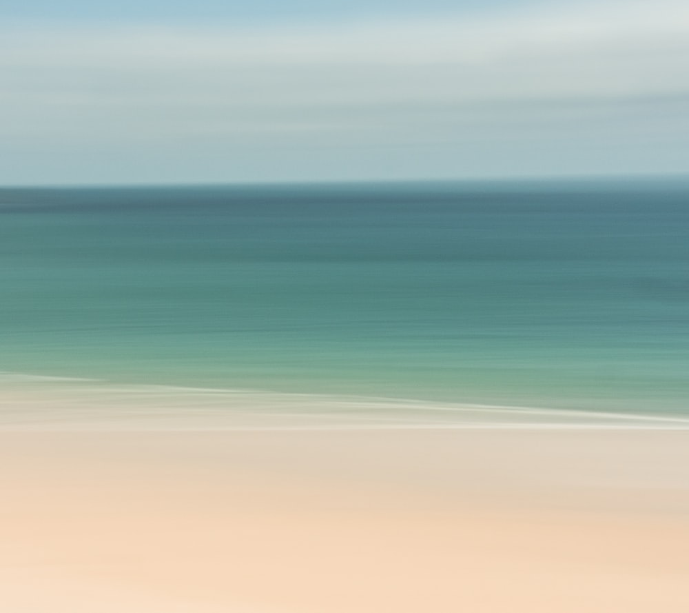 a blurry photo of a beach with a blue ocean in the background