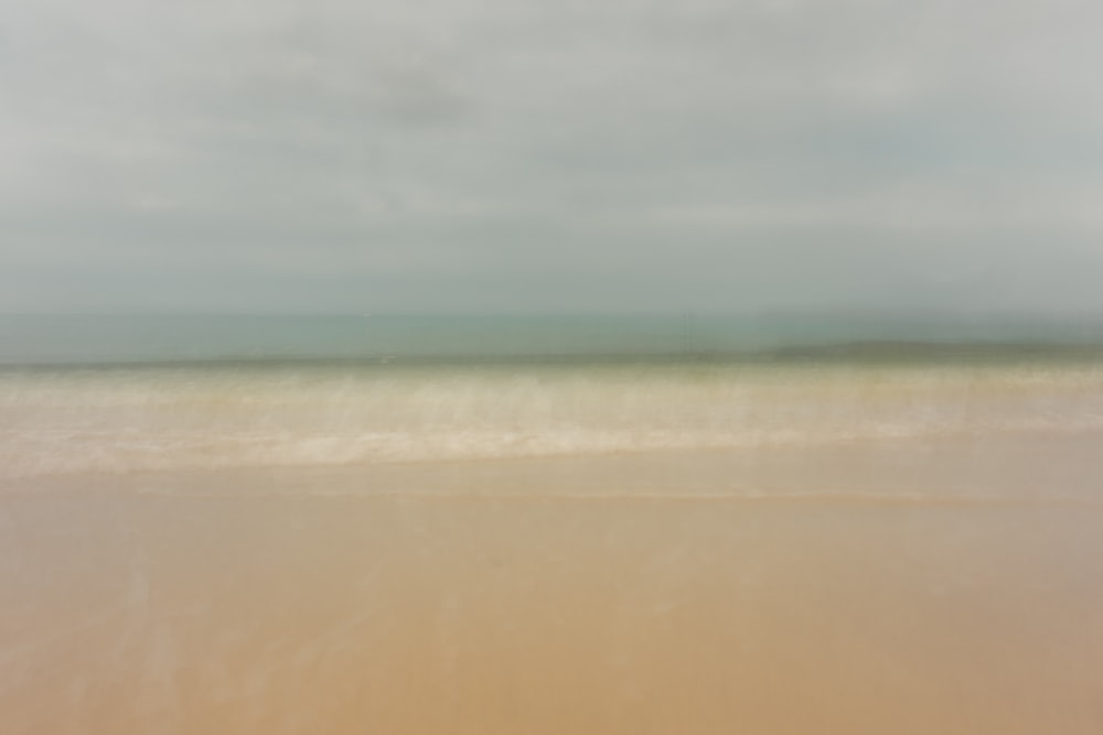a blurry photo of a beach and ocean