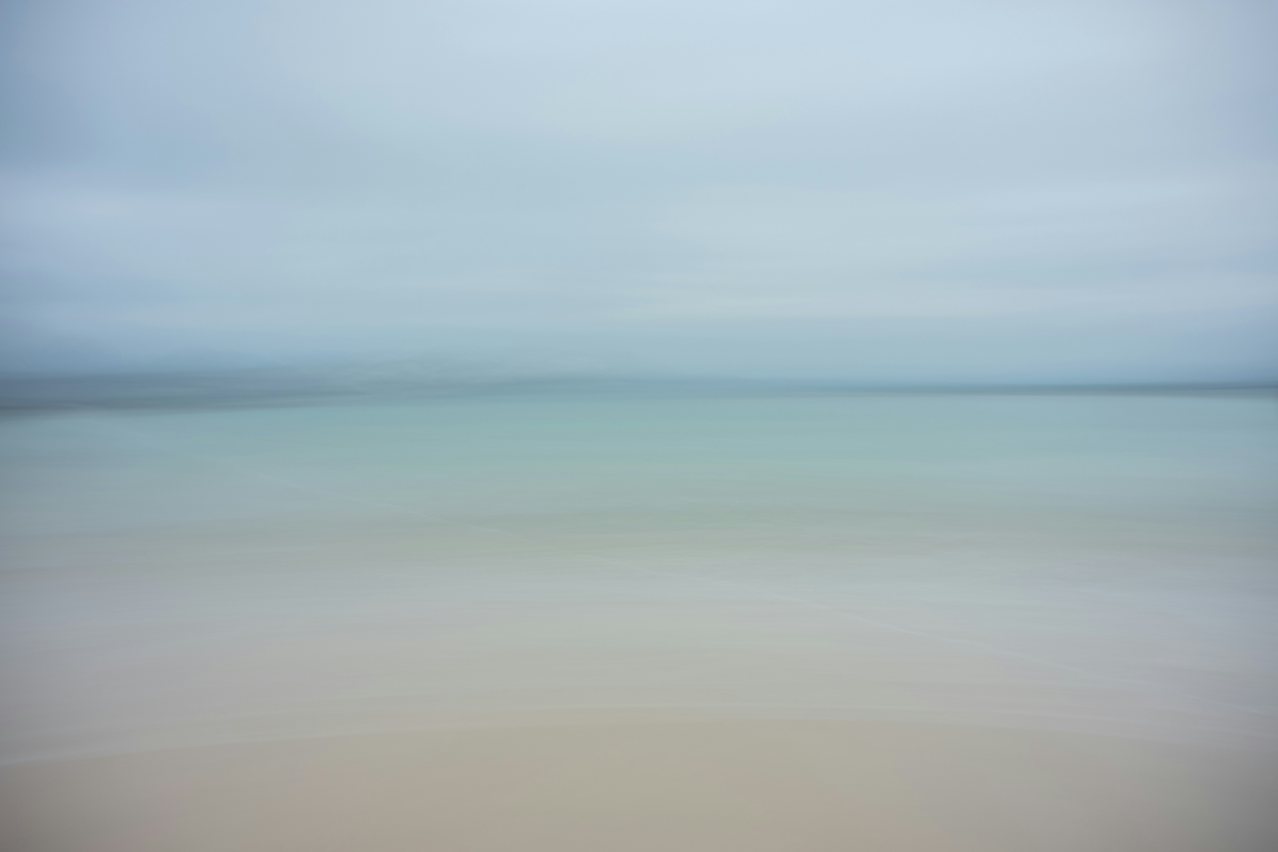 A blurry photo of a beach with water