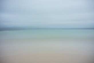 A dreamy horizon blending sea and sky with hints of deep blues and sandy tones