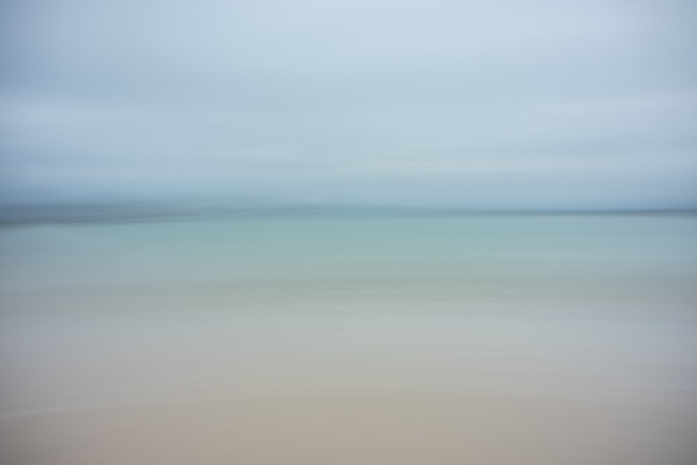 a blurry photo of a beach with water