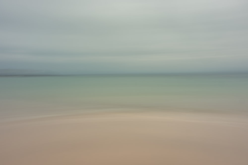 a blurry photo of a beach with water