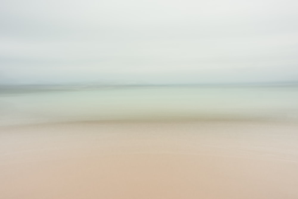 a blurry photo of a beach and ocean