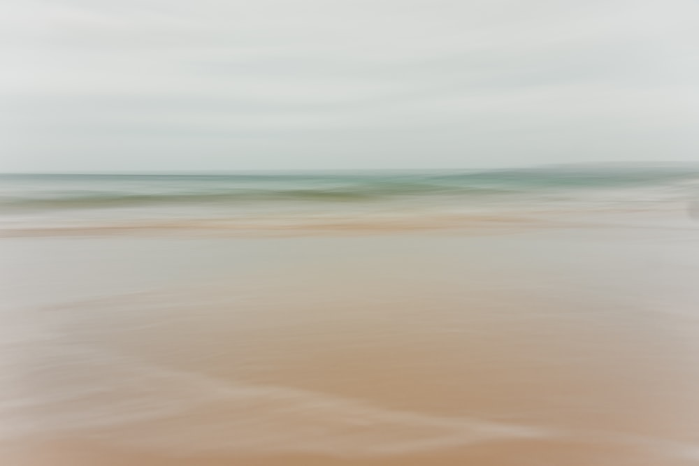 a blurry photo of a beach with a boat in the distance