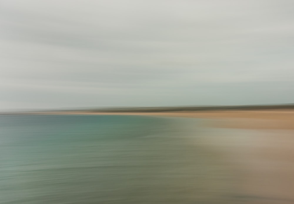 a blurry photo of a beach and water