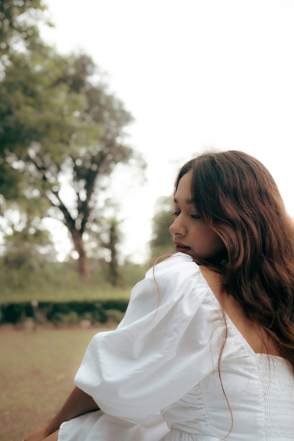 a woman in a white dress standing in a field