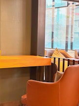 A warm, inviting office space with soft brown and gold accents, featuring a comfortable seating area and gentle natural light.