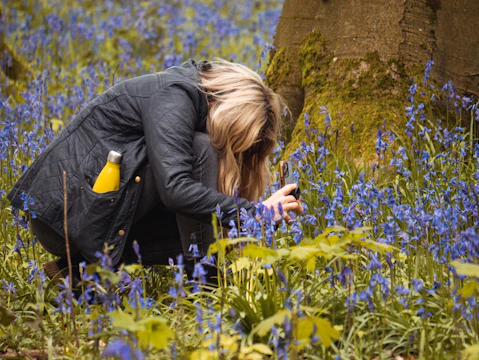 Juris Prokofjevs surveying a Natura 2000 site, clipboard in hand, surrounded by wildflowers