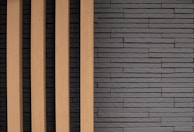 Sleek granite slab leaning against a minimalist white wall, showcasing natural texture.